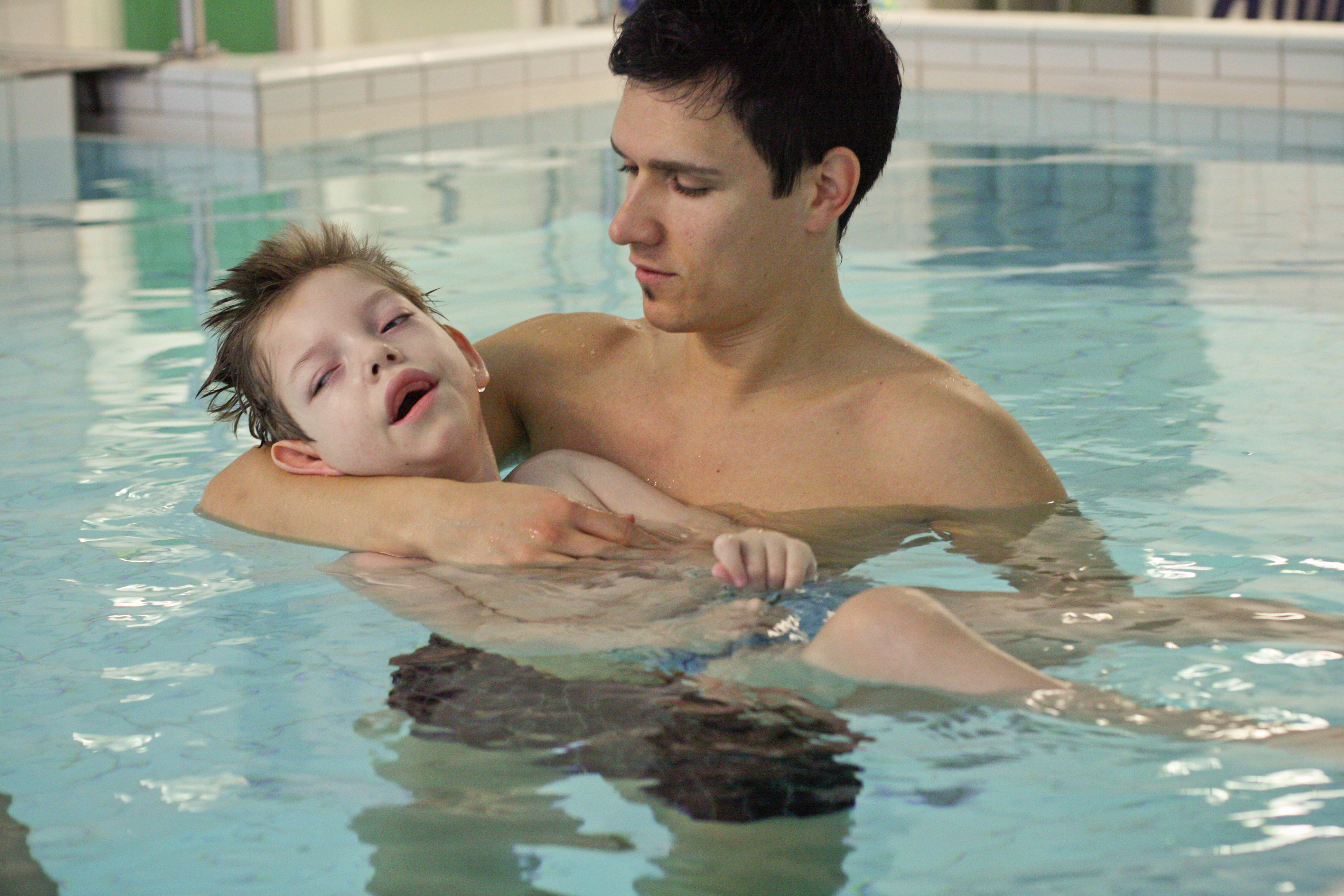 Kind mit Pfleger im Wasser